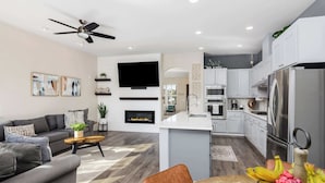 A modern living room with a sofa, coffee table, and a fireplace. - Wildflower (Windsor)