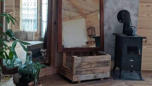 A wooden cabin interior with a large mirror, a stove, and potted plants. - Yourte in Provence , at la Mauvaise Herbe, Barjols (Barjols)
