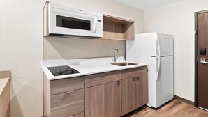 Cocina compacta con microondas, pileta y refrigerador.