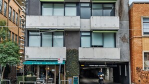 Ένα πολυώροφο κτίριο με μια πράσινη τέντα στο ισόγειο, στην οποία αναγράφεται η επιγραφή «Harper's Kitchen».