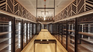 A modern, well-lit room with a long wooden table and glass-fronted storage units on either side. - Chic 1-bed With a Sleek Balcony Near Shops (Melbourne)