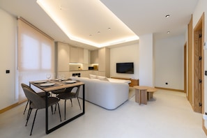A modern, well-lit room with a dining area, a sofa, a TV, and a wooden wardrobe. - M Scr7b1 Amplio Piso Exterior de un Dormitorio e (Madrid)