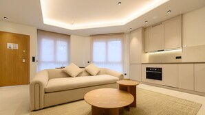 A modern living room with a sofa, two wooden side tables, and a large window. - M Scr7b1 Amplio Piso Exterior de un Dormitorio e (Madrid)