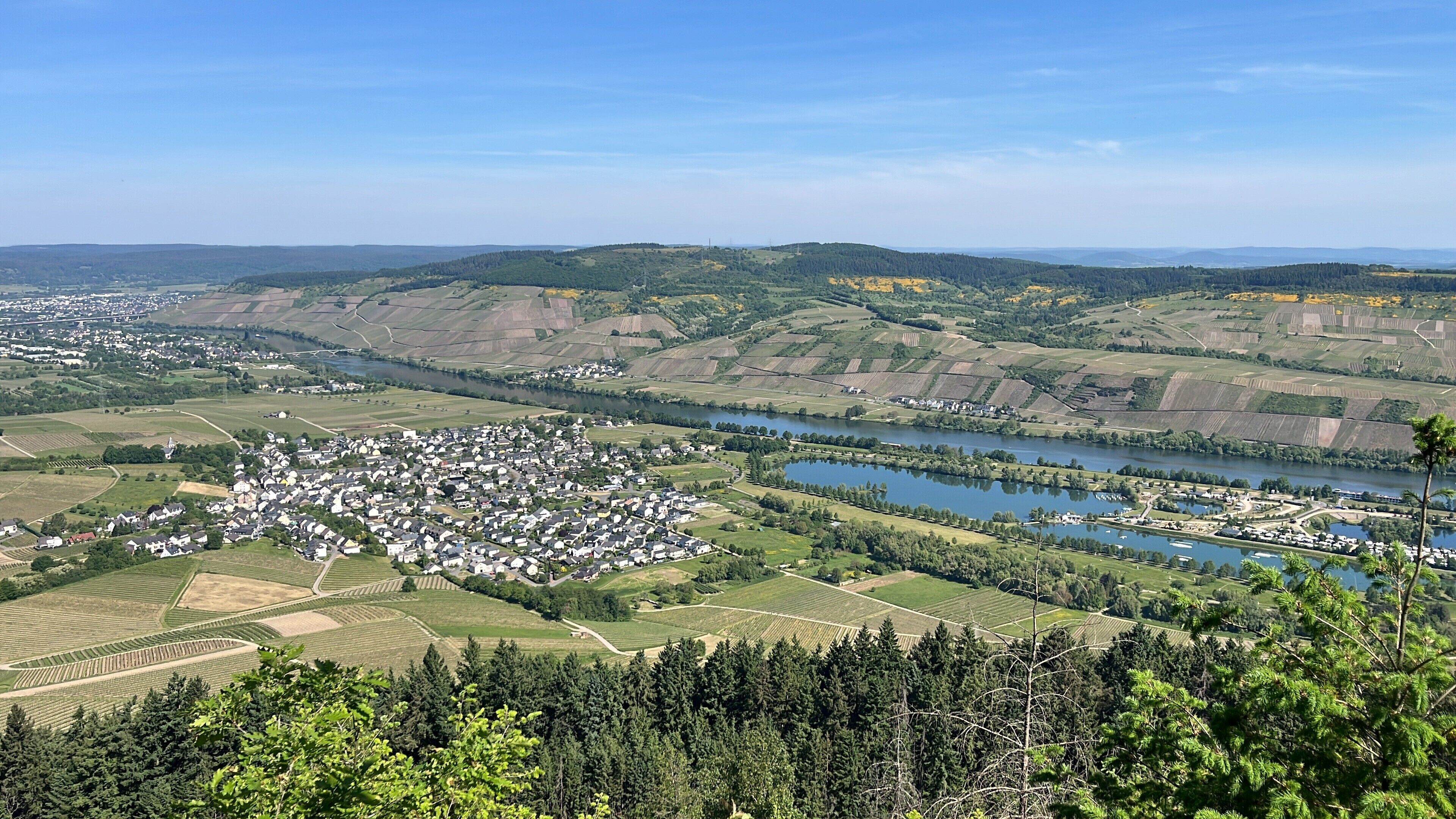 A rural landscape with a river, fields, and a small village.