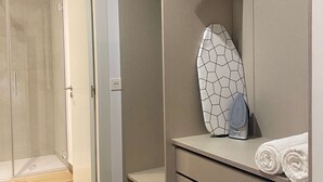 A modern bathroom with a walk-in shower, a towel rack, and a built-in storage unit. - w Modern 2BR With Terrace in Chueca (Madrid)