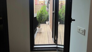A hallway leading to a sliding glass door with a view of a courtyard. - w Impressive 3BR w Sunny Terrace in Chueca (Madrid)