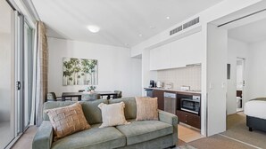 Una sala de estar moderna con un sofá, una mesa de centro y una zona de comedor con una mesa y sillas.
