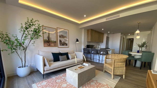 Una sala de estar moderna con un sofá, una mesa de centro y un comedor con sillas y una mesa.