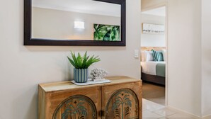 Un meuble en bois orné de sculptures décoratives, un miroir au-dessus et une plante en pot sur le dessus.