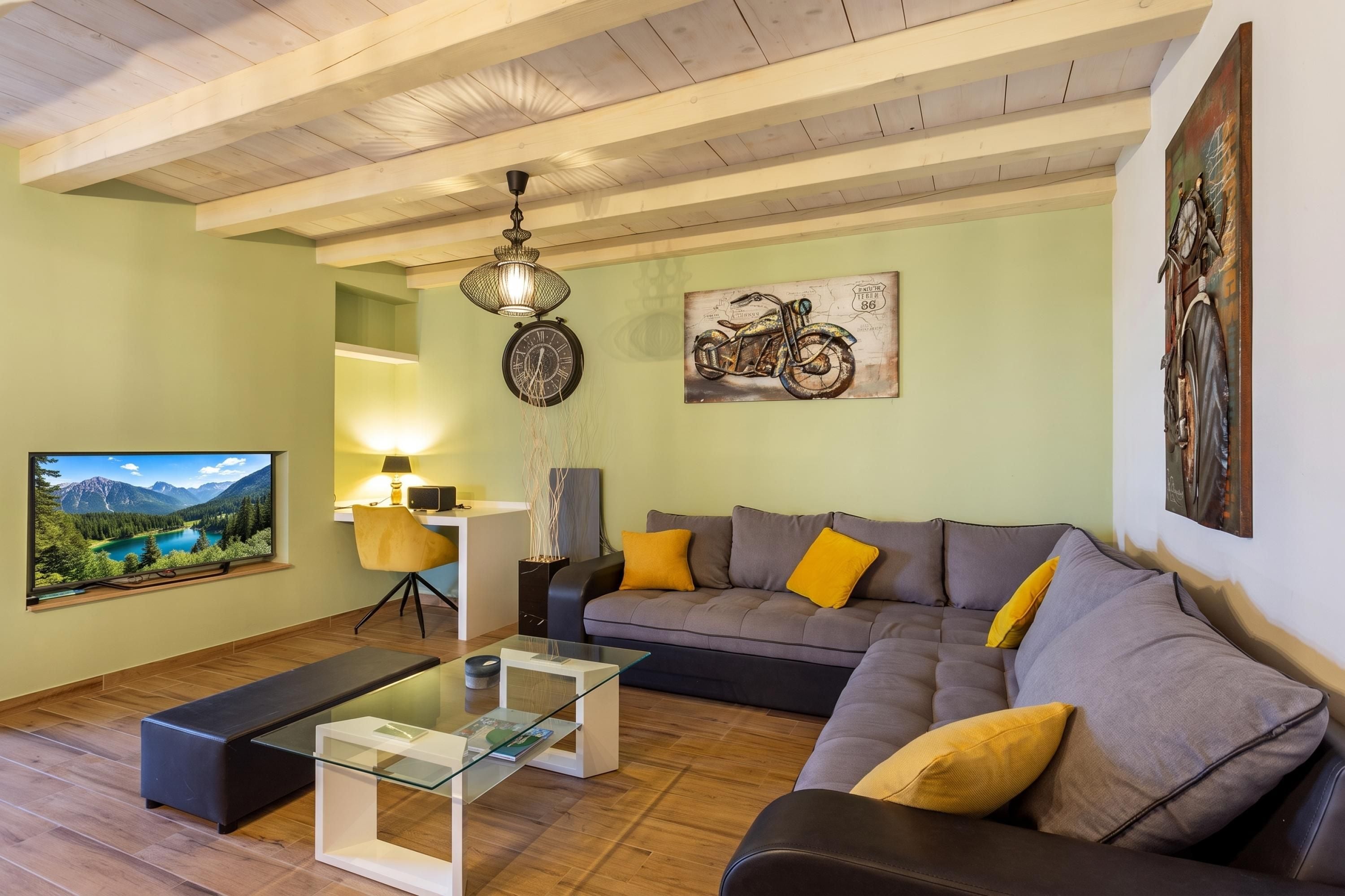 A living room with a sofa, a coffee table, a TV, and artwork on the walls.