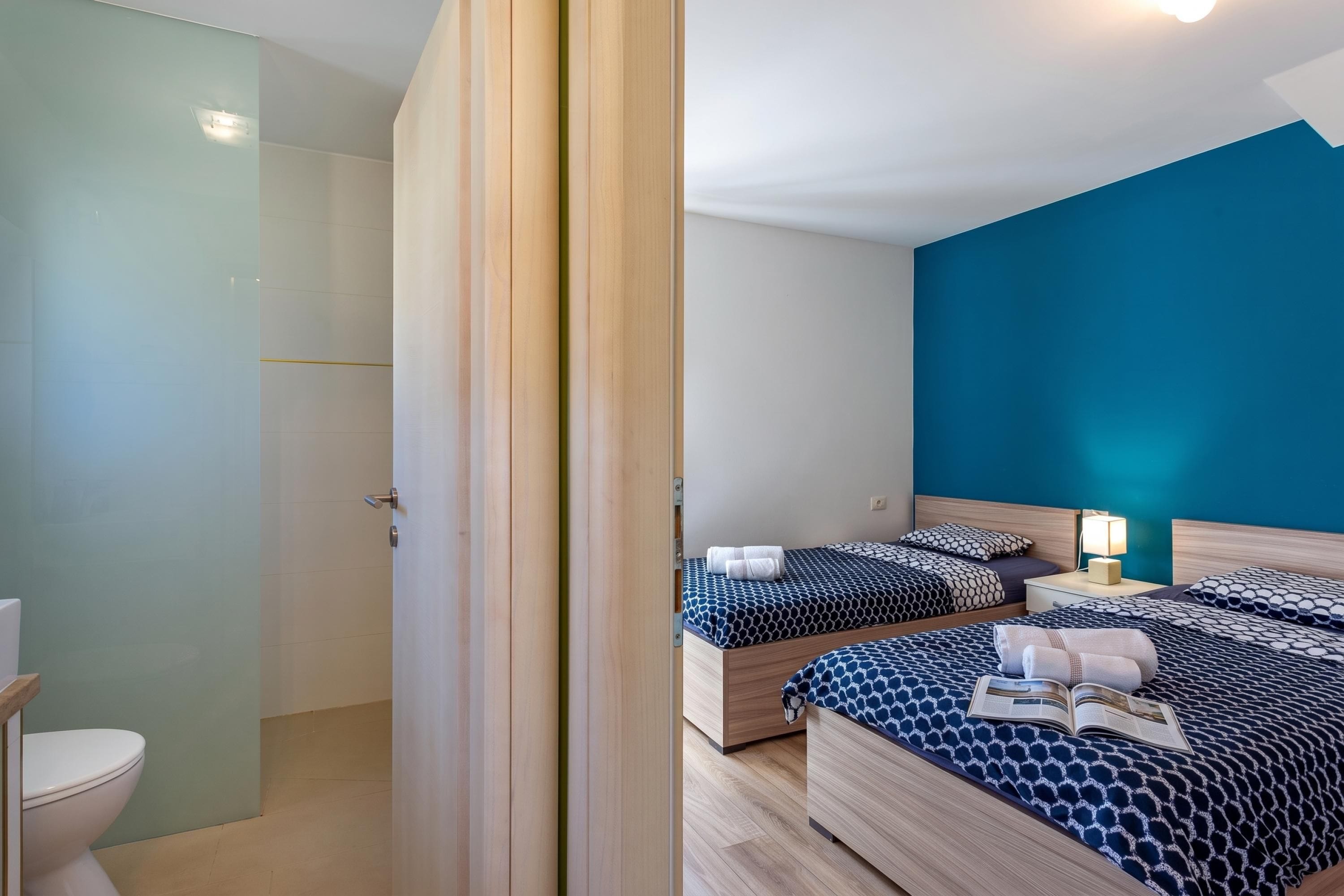 Ein Hotelzimmer mit zwei Betten, einem Badezimmer und Meerblick.