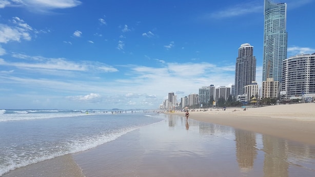 A beach with a sandy shore and a city skyline in the background. - Lakeside Family Oasis With Pool, Gym and Balcony (Gold Coast)