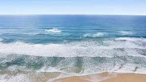 A beach with waves approaching the shore.