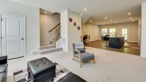 Un grand espace de vie comprenant un escalier, un coin repas et une cuisine.