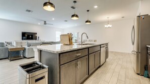 A modern kitchen with a central island, stainless steel appliances, and pendant lighting. - Near Beaches & Golfing: Port St Lucie Home w/ Yard (Port Saint Lucie)