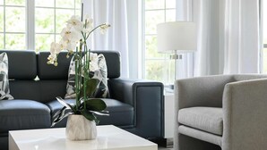 A modern living room with a grey sofa, a white coffee table, and a grey armchair. - Sleek & Stylish Stay, Mins to Magic, MP68 (Orlando)