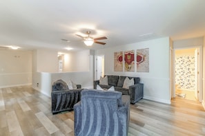 A living room with a ceiling fan, a sofa set, and a patterned wall. - Championsgate Resort Perks! Fun-filled Family Home (Davenport)
