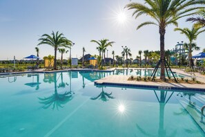 A clear blue pool surrounded by palm trees and shaded areas. - Championsgate Resort Perks! Fun-filled Family Home (Davenport)