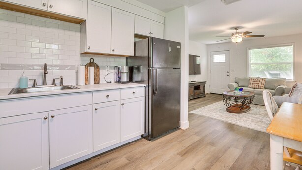 A modern kitchen with white cabinets, a stainless steel refrigerator, and a wooden countertop. - 2 Mi to River District! Fort Myers Retreat w/ Yard (Fort Myers)