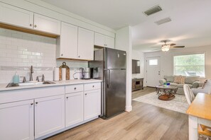 A modern kitchen with white cabinets, a stainless steel refrigerator, and a wooden countertop. - 2 Mi to River District! Fort Myers Retreat w/ Yard (Fort Myers)