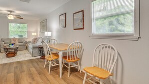 A living room with a wooden floor, a dining table with chairs, a sofa set, and a ceiling fan. - 2 Mi to River District! Fort Myers Retreat w/ Yard (Fort Myers)
