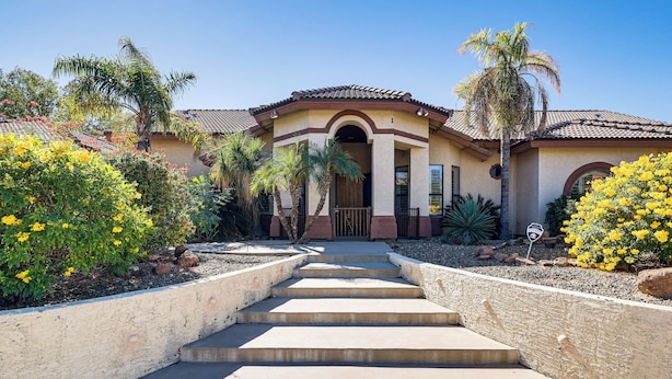 A house with a front entrance, steps leading up to it, and a garden with various plants and flowers. - Groups Welcome! Home w/ Pool + Patio in N Phoenix (Phoenix)