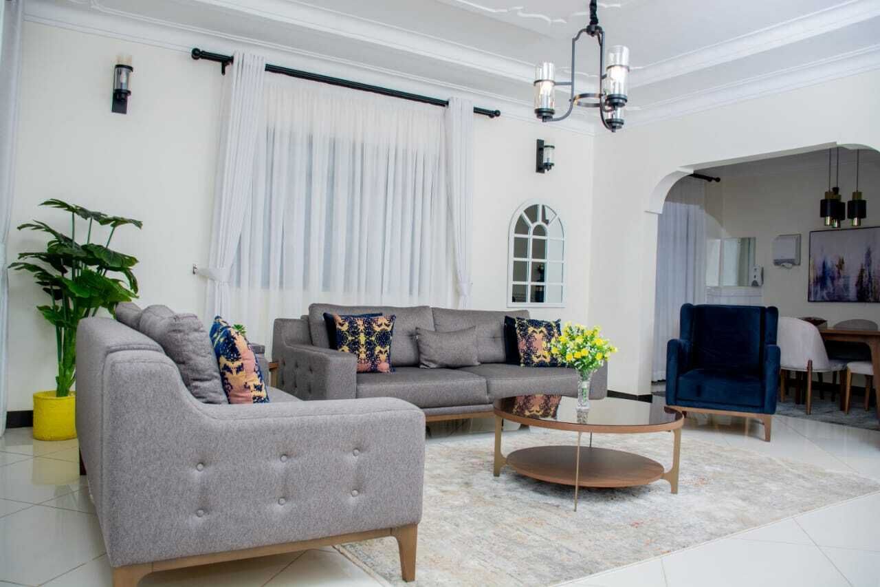 A modern living room with a grey sofa, a coffee table, and a blue armchair.