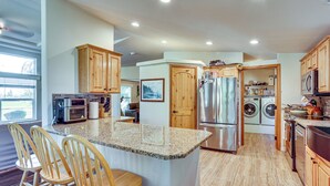 A modern kitchen with granite countertops, wooden cabinets, a stainless steel refrigerator, and a built-in oven. - Hike, Ski, Fish & Bike: Bellingham All-season Base (Bellingham)