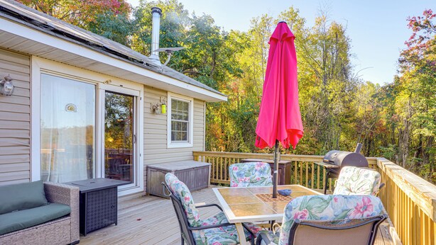 A deck with outdoor furniture, a grill, and a large umbrella. - 7 Mi to Main Street: Cabin w/ Deck in Stanley! (Stanley)