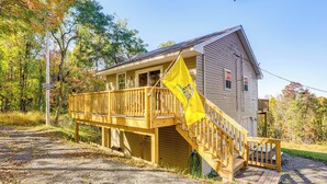 A wooden cabin with a deck and a flag. - 7 Mi to Main Street: Cabin w/ Deck in Stanley! (Stanley)