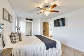 A bedroom with a bed, ceiling fan, TV, and framed quotes on the wall. - Black Hills, Sturgis Rally Base w/ Trailer Parking (Piedmont)
