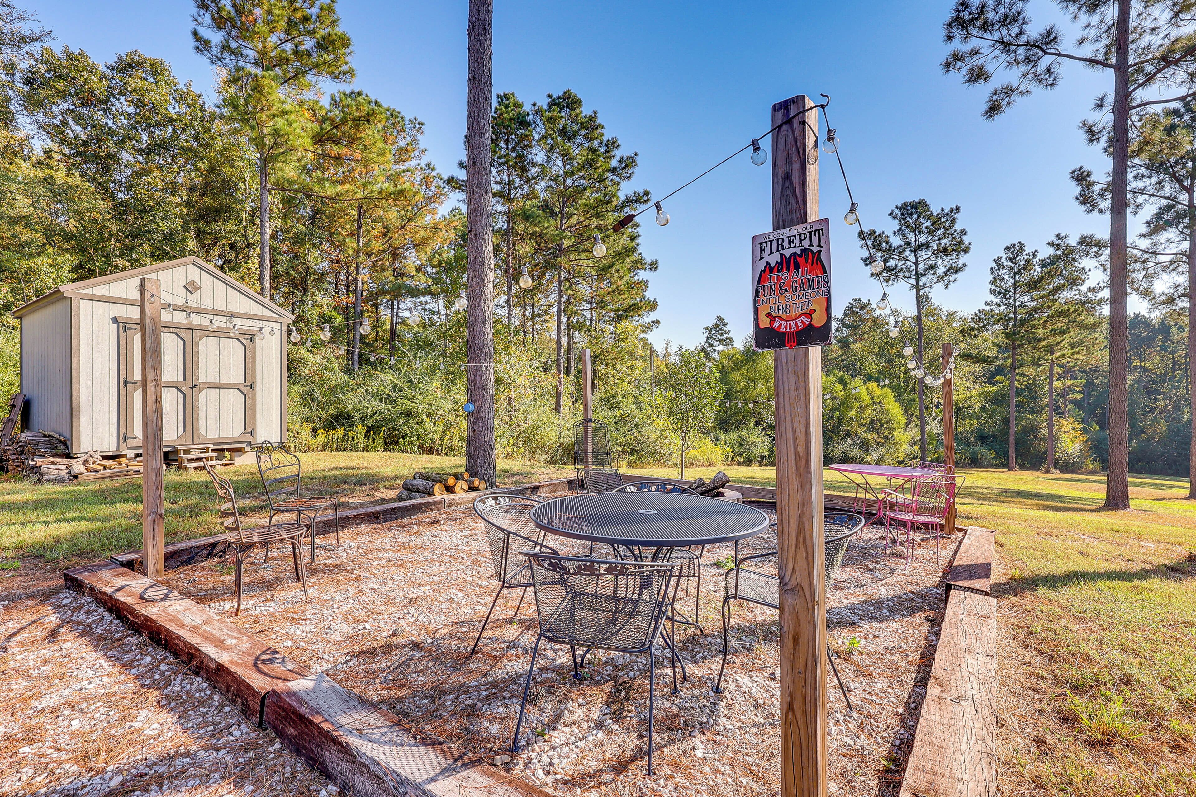 A patio with a round table and chairs, surrounded by a wooden deck and gravel.
