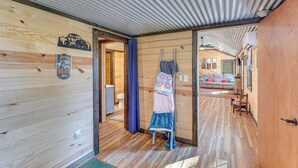 A wooden interior with a bathroom, a living area with a sofa, and a ceiling fan. - ~ 1 Mi to Lake Greeson & Ramp: 'lazy Bear Cabin' (Amity)