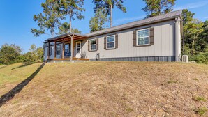 A single-story house with a covered porch, large windows, and a sloped roof. - ~ 1 Mi to Lake Greeson & Ramp: 'lazy Bear Cabin' (Amity)