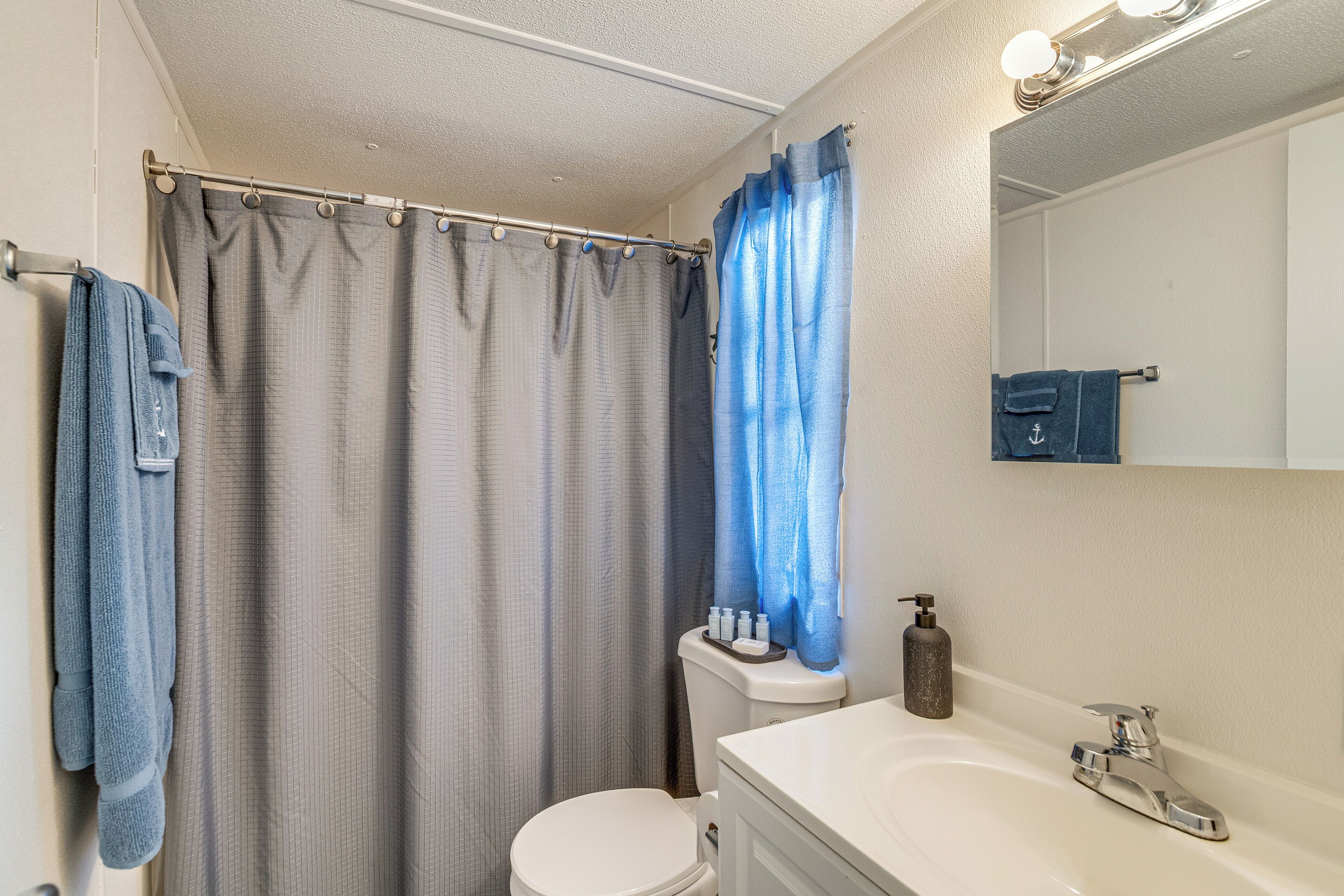 A bathroom with a toilet, sink, and shower curtain.