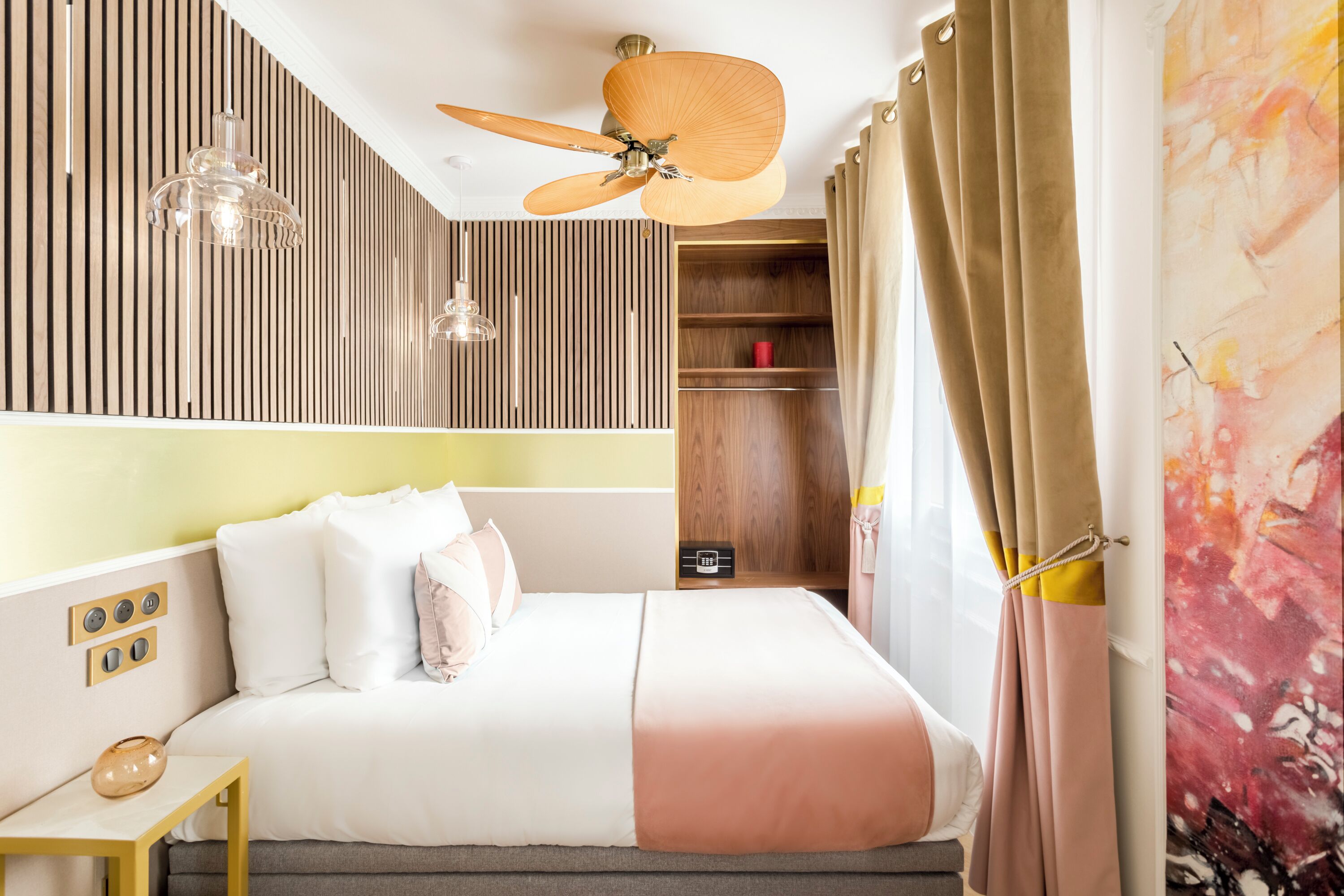 Ein modernes Schlafzimmer mit Bett, Nachttischen, Deckenventilator, Kleiderschrank und einer Wandregal.