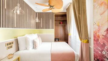 A modern bedroom with a bed, bedside tables, a ceiling fan, a wardrobe, and a wall-mounted shelf.