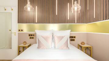 A modern bedroom with a large bed, two bedside tables, a wooden slat wall, and pendant lighting.
