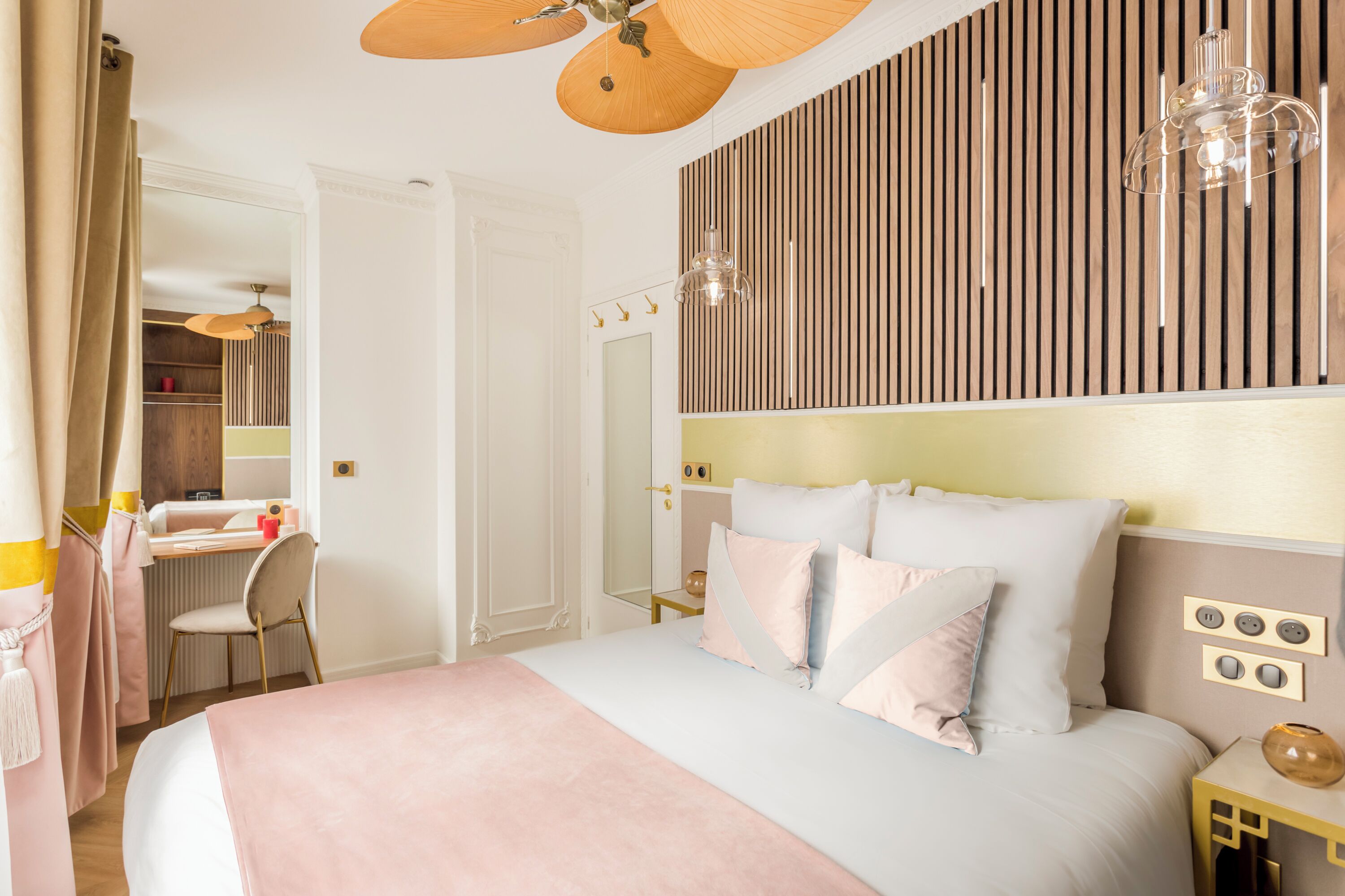 A bedroom with a bed, bedside table, and a wall-mounted light fixture.