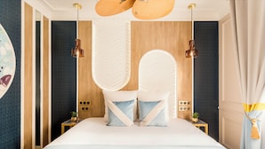 A modern bedroom with a large bed, two bedside tables, and a ceiling fan.