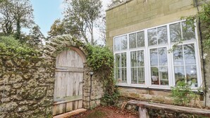 A stone building with a wooden door and a large window.