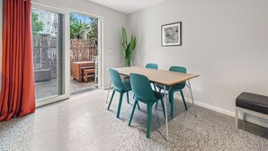 A dining area with a table and chairs, a bench, a plant, and a framed picture on the wall. - Convenient Bayside Living at the Edge of the City (Melbourne)