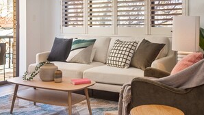 A living room with a sofa, a coffee table, and a chair. - Cosy Unit With Parking Near New Farm Park & River (Brisbane)
