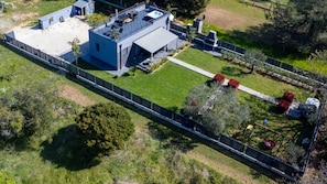 Oversigtsbillede af et moderne hus med en tagterrasse, swimmingpool og en velholdt have.