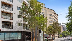 Un edificio moderno con varios pisos, ventanas amplias y balcones.
