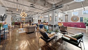A spacious living area with a high ceiling, exposed ductwork, and a variety of seating options including sofas and chairs. - Industrial Loft - Sleeps 10 - FREE Valet (Dallas)