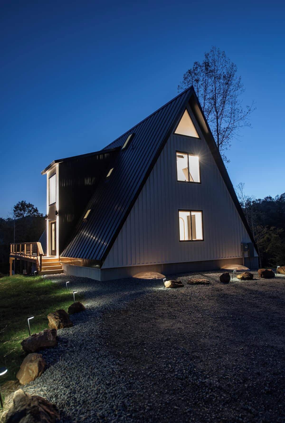 Un edifici modern amb teulada triangular, un camí de grava i unes escales de fusta que condueixen a l'entrada.