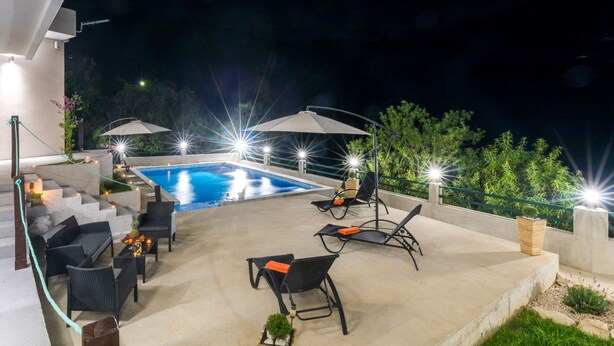 A rooftop pool area with outdoor seating and umbrellas. - Apartment Zelenika Villa by Villas Guide (Ploce)