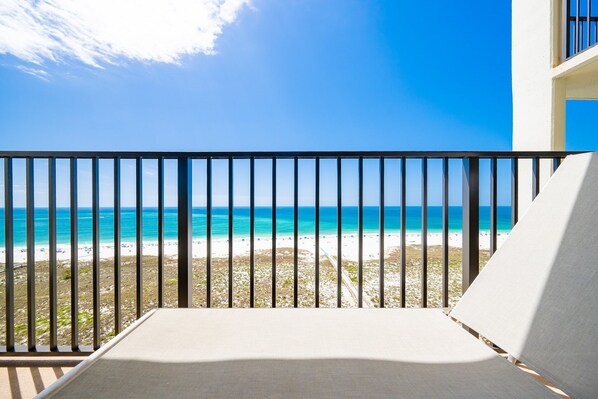 A balcony with a view of a beach and ocean.