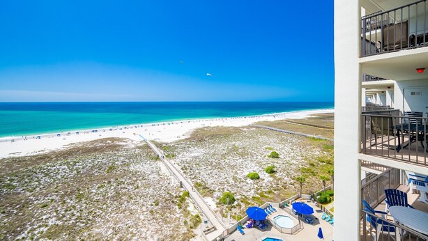 A beach view from a balcony with a pool and lounge chairs. - Phoenix Vi 61010 2 Bedroom Condo (Orange Beach)